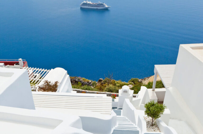 Круизен кораб край Santorini, Гърция, с изглед към синьото Егейско море